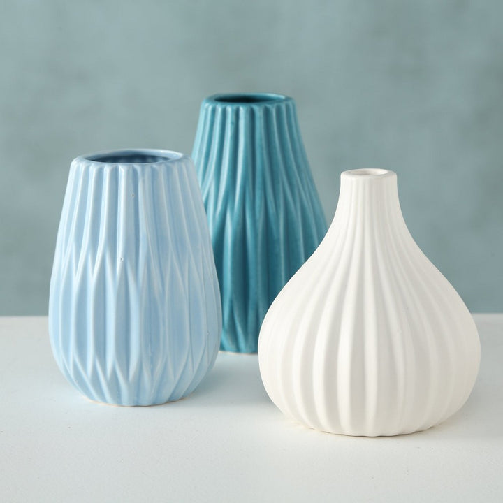 Vase Wilma Porzellan in Hellblau, Türkis und Weiß auf einem Tisch, modern und minimalistisch.