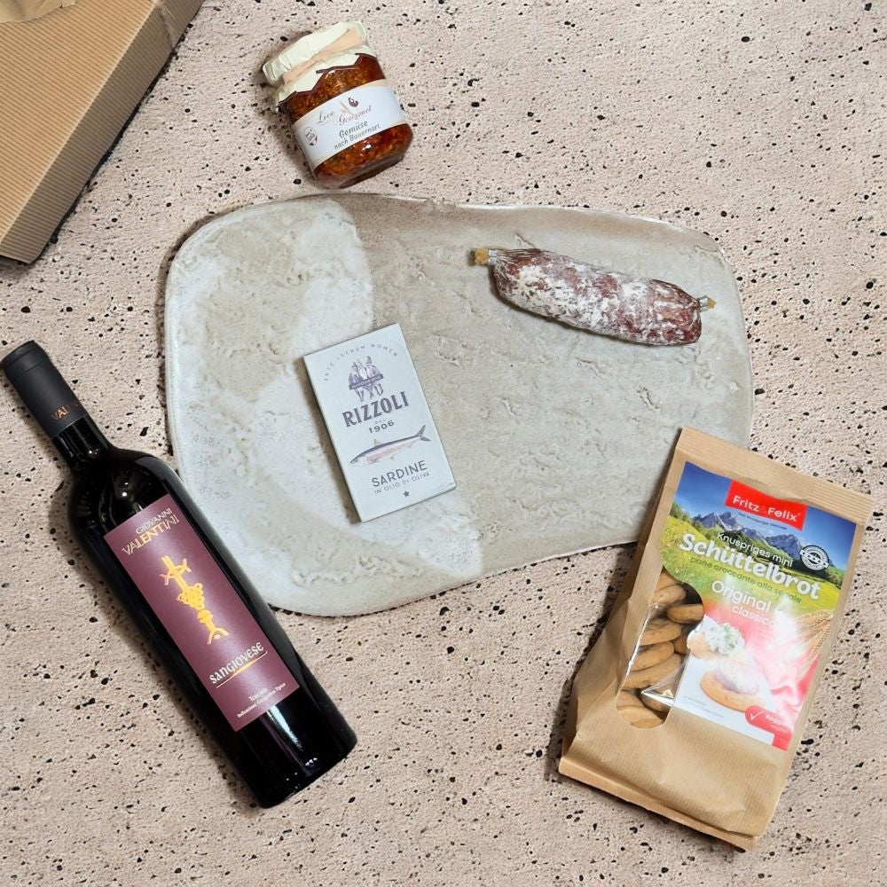 Ausgepackte Italienische Feinkost Geschenkbox mit Valentini Sangiovese Toscana IGT 2022 Jägersalami Cacciatore Rizzoli Sardine in olio di oliva Fritz Felix Mini Schüttelbrot Original und Live Gourmet Gemüse nach Bauernart