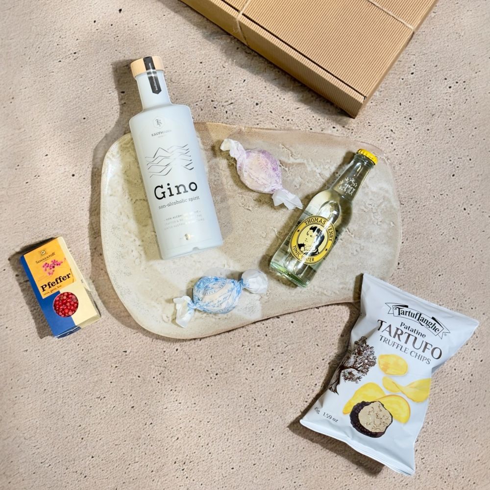 Ausgepackte Alkoholfreie Geschenkbox mit Kaufmann Spirits Gino non alcoholic spirit Thomas Henry Tonic Water TartufLanghe Patatine Tartufo Truffle Chips Sonnentor Pfeffer rosa ganz bio und Brutti e Buoni Mandelgebäck