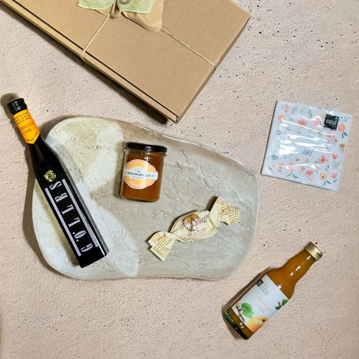 Ausgepackte Marillen Geschenkbox mit Gölles Marillen Essig 250 ml Floberry Bergmarillen Mamelad 200g Stift Klosterneuburg Marillennektar 0,20 l ppd Oh Happy Day Cocktail Servietten und Amaretti Eugenia