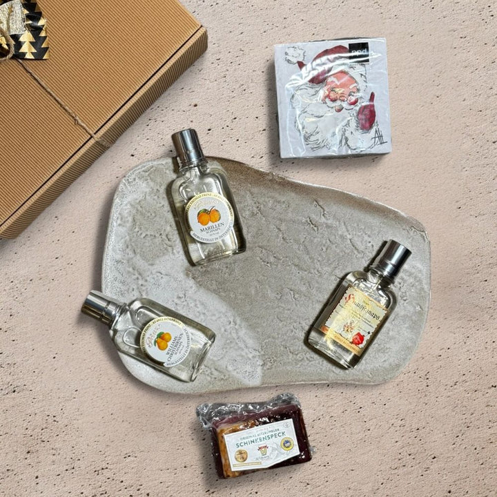 Ausgepackte Schnaps Geschenkbox mit Prinz Hausschnaps Marille Prinz Marillen Schnaps Prinz Williams Birnen Schnaps Metzgerei Huber Schinkenspeck und ppd Jolly St Nick Servietten