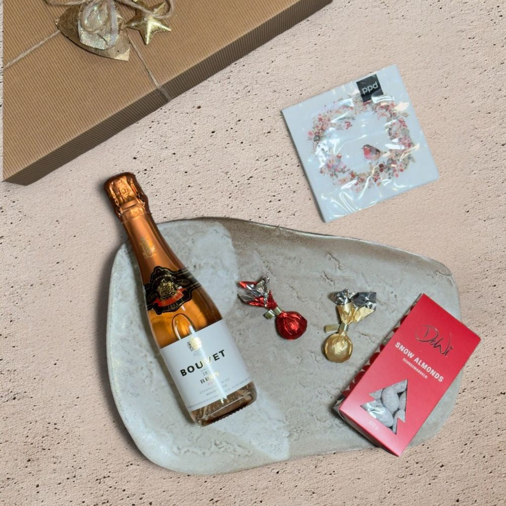 Ausgepackte Sekt Geschenkbox Weihnachten mit Bouvet Brut 1851 Rosé Methode Traditionelle DeWi Schneemandeln Venchi rote goldene Weihnachtskometen ppd Beautiful Christmas Wreath Servietten und Metall Weihnachtsmotive mit Schelle weiß gold