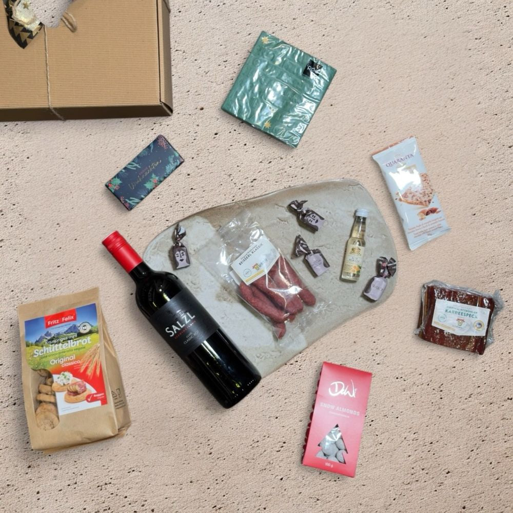 Ausgepackte Wein Geschenkbox Österreich mit Salzl Cuvée Classic Rot 2022 Metzgerei Huber Karreespeck Hubers Beisserl Prinz Alte Marille Fritz Felix Mini Schüttelbrot DeWi Schneemandeln Quaranta Florentine Grafik Werkstatt Schokolade ppd Christmas embossed green Servietten und Tartufo schwarz