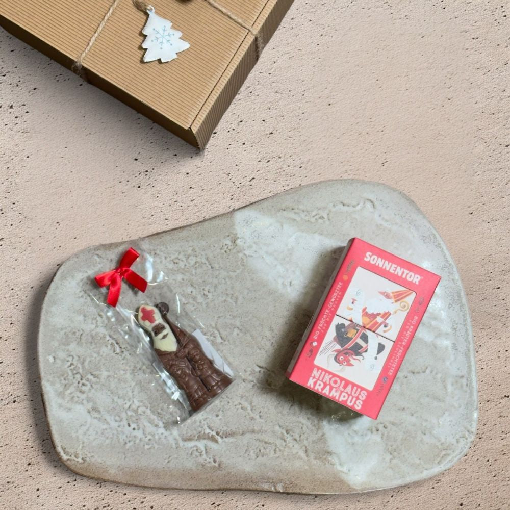 Ausgepackte Nikolaus Geschenkbox mit Sonnentor Nikolaus und Krampus Tee Süßwaren Albrecht Mini Bischof Schokolade und Metall Stern Herz Baum Anhänger mit Schelle blau weiß gold